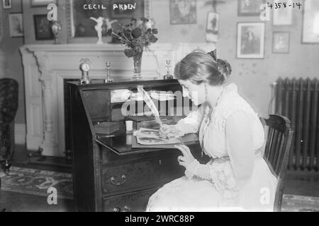 Cecil Arden, photographie montre la mezzo-soprano et chanteuse d'opéra contralto américaine Cecil Arden (1894-1989), assise à son bureau, signant ses portraits avec un stylo à plume. Arden a été actif au cours des premières décennies du XXe siècle., entre CA. 1915 et env. 1920, négatifs en verre, 1 négatif : verre Banque D'Images