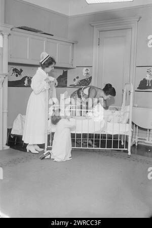 Gluck, photographie montre la chanteuse d'opéra roumano-américaine Alma Gluck (1884-1938) avec son fils Efrem Zimbalist Jr. (1918-2014) dans un berceau, sa fille Maria agenouillée à côté du berceau et une infirmière., 1918 ou 1919, négatifs en verre, 1 négatif : verre Banque D'Images