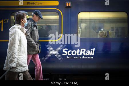 Photo du dossier datée du 23/05/22 de voyageurs passant devant un train ScotRail à la gare Waverley d'Édimbourg. Plus de 1,5 millions de livres sterling ont été versés en compensation par ScotRail depuis la nationalisation du service, selon de nouveaux chiffres. Le service ferroviaire a été introduit dans la propriété publique en 2022 après une série de défaillances de l'ancien opérateur Abellio. Date d'émission : mardi 12 mars 2024. Banque D'Images