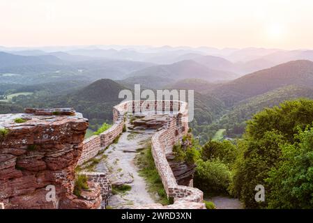 Lever de soleil lumineux sur les ruines du château de Wegelnburg et la forêt du Palatinat, Rhénanie-Palatinat, Allemagne Banque D'Images