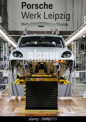 Leipzig, Allemagne. 11 mars 2024. Une Porsche Macan traverse la chaîne de montage de l'usine de Leipzig. Le constructeur de véhicules sportifs et tout-terrain Porsche publie mardi 12 mars ses chiffres d'affaires de l'année écoulée à l'usine Porsche de Leipzig. Crédit : Jan Woitas/dpa/Alamy Live News Banque D'Images