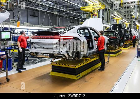 Leipzig, Allemagne. 11 mars 2024. Les employés assemblent une Porsche Panamera à l'usine de Leipzig. Le constructeur de véhicules sportifs et tout-terrain Porsche publiera ses chiffres d'affaires de l'année écoulée à l'usine Porsche de Leipzig mardi 12 mars. Crédit : Jan Woitas/dpa/Alamy Live News Banque D'Images