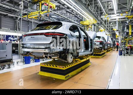 Leipzig, Allemagne. 11 mars 2024. Porsche Macan au volant de la chaîne de montage de l'usine de Leipzig. Le constructeur de véhicules sportifs et tout-terrain Porsche publie mardi 12 mars ses chiffres d'affaires de l'année écoulée à l'usine Porsche de Leipzig. Crédit : Jan Woitas/dpa/Alamy Live News Banque D'Images