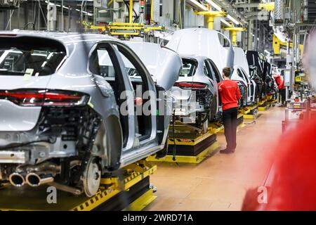 Leipzig, Allemagne. 11 mars 2024. Un employé assemble une Porsche Macan à l'usine de Leipzig. Le constructeur de véhicules sportifs et tout-terrain Porsche publiera ses chiffres d'affaires de l'année écoulée mardi 12 mars à l'usine Porsche de Leipzig. Crédit : Jan Woitas/dpa/Alamy Live News Banque D'Images