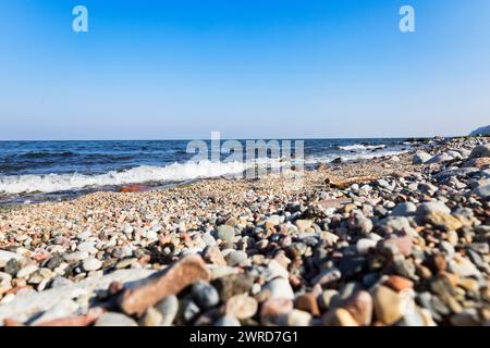 La vague de la mer bat contre une pierre sur le rivage. Mer bleue et rivage rocheux. Banque D'Images