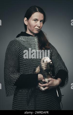 Femme armée d'infanterie médiévale vêtue d'armure de chaîne avec furet Banque D'Images