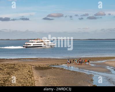 Randonnée dans la vase à basse eau et ferry dans le canal de Wittdun, île d'Amrum, Frise du Nord, Schleswig-Holstein, Allemagne Banque D'Images