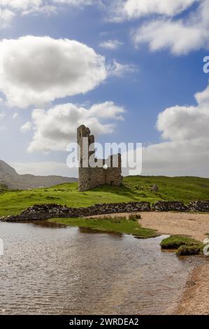 Les ruines antiques du château d'Ardvreck se dressent sur un monticule verdoyant, à côté d'un lac ondulé, avec un ciel vibrant de nuages moelleux au-dessus, reflétant Scotla Banque D'Images