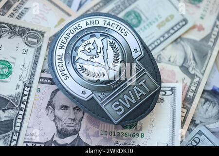 KIEV, UKRAINE - 9 MARS 2024 badge SWAT américain sur de nombreux billets en dollars américains Fermer Banque D'Images