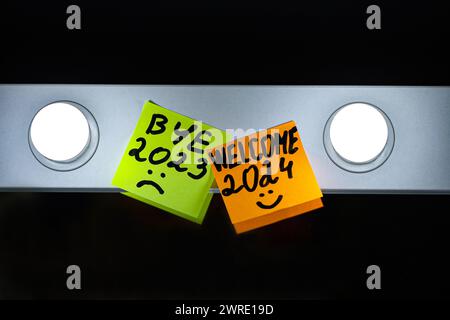 Message sur des feuilles colorées collées sur le bord d'un miroir blanc moderne, avec le concept de finir l'année 2023 et de commencer une nouvelle année 2024. Le Banque D'Images