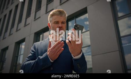 En colère stressé agressif criant fou homme d'affaires senior argumentant conflit conflit problème de travail parler téléphone mobile irrité caucasien mature Banque D'Images