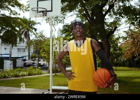 Portrait d'un joueur de streetball souriant et confiant debout sur un terrain extérieur Banque D'Images