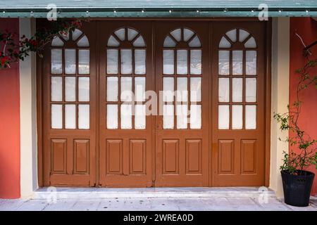 Vieille porte en bois avec fenêtres en verre dans la vieille ville en Europe. Entrée de maison avec belle porte en bois voûtée et fenêtre de traverse. européen traditionnel Banque D'Images