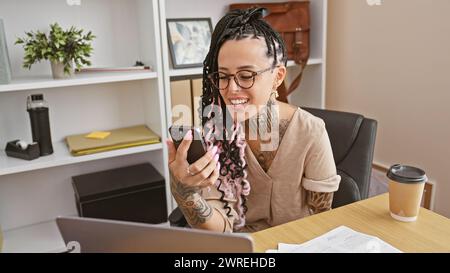 Une femme hispanique confiante, une travailleuse amputée, riant tout en participant à un appel vidéo professionnel sur son lieu de travail Banque D'Images