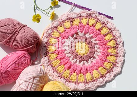 Photo vue de dessus de boules de fil de coton, crochet crochet et fleurs. Elément décoratif fait à la main. Banque D'Images