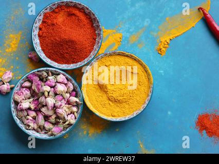 Nature morte avec différentes épices sur fond bleu avec espace de copie. Couleurs vives des assaisonnements alimentaires. Concept d'alimentation saine. Banque D'Images
