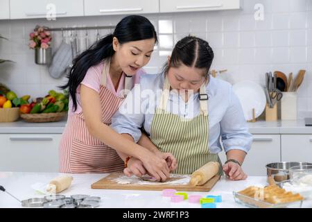 Deux mères et leurs enfants pratiquent la cuisson dans la cuisine à la maison Banque D'Images