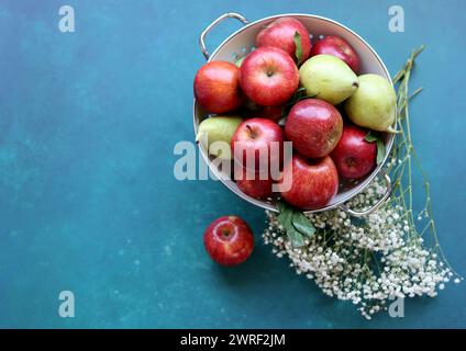 Nature morte avec des pommes rouges fraîches dans une passoire. Fond texturé bleu avec espace de copie. Concept manger sain. Banque D'Images