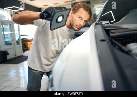 Masculin effectue une inspection de contrôle de la carrosserie de la voiture Banque D'Images