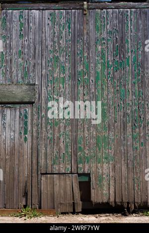 Vieux murs de briques et portes en bois peintes en vert lourd et fanées, Knighton, Powys. Banque D'Images