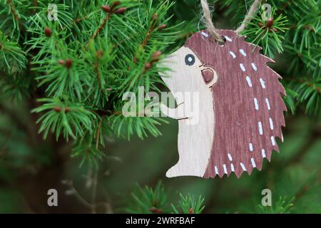 Décoration de Noël hérisson en bois accrochée à l'arbre. Carte de Noël. Espace pour le texte. Banque D'Images