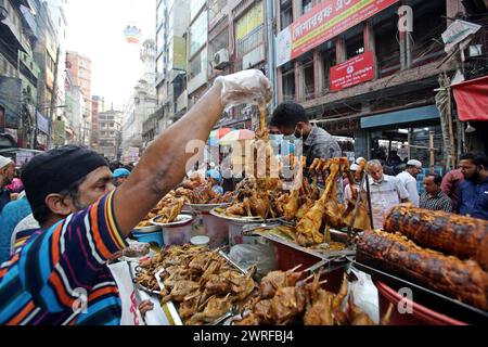 Les musulmans bangladais achètent de la nourriture pour rompre leur jeûne pendant le premier jour du mois de jeûne du Ramadan sur un marché alimentaire traditionnel au bazar de Chalk, à Dhaka, au Bangladesh, le 12 mars 2024. Le mois sacré du Ramadan pour les musulmans est le neuvième mois du calendrier islamique, et on croit que la révélation du premier verset du Coran a eu lieu au cours de ses 10 dernières nuits. C’est aussi un moment de socialisation, principalement le soir après avoir rompu le jeûne, et un déplacement de toutes les activités vers la fin de la journée dans la plupart des pays. Photo Habibur Rahman/ABACAPRESS.COM Banque D'Images