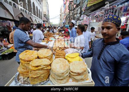 12 mars 2024, Dhaka, Wari, Bangladesh : les musulmans bangladais achètent de la nourriture pour rompre leur jeûne pendant le premier jour du mois de jeûne du Ramadan sur un marché alimentaire traditionnel au bazar de Chalk, à Dhaka, Bangladesh, le 12 mars 2024. Le mois sacré du Ramadan pour les musulmans est le neuvième mois du calendrier islamique, et on croit que la révélation du premier verset du Coran a eu lieu au cours de ses 10 dernières nuits. C’est aussi un moment de socialisation, principalement le soir après avoir rompu le jeûne, et un déplacement de toutes les activités vers la fin de la journée dans la plupart des pays. (Crédit image : © Habibur Rahman/ZUMA Pre Banque D'Images