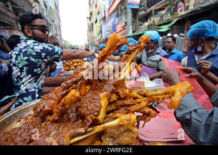 12 mars 2024, Dhaka, Wari, Bangladesh : les musulmans bangladais achètent de la nourriture pour rompre leur jeûne pendant le premier jour du mois de jeûne du Ramadan sur un marché alimentaire traditionnel au bazar de Chalk, à Dhaka, Bangladesh, le 12 mars 2024. Le mois sacré du Ramadan pour les musulmans est le neuvième mois du calendrier islamique, et on croit que la révélation du premier verset du Coran a eu lieu au cours de ses 10 dernières nuits. C’est aussi un moment de socialisation, principalement le soir après avoir rompu le jeûne, et un déplacement de toutes les activités vers la fin de la journée dans la plupart des pays. (Crédit image : © Habibur Rahman/ZUMA Pre Banque D'Images