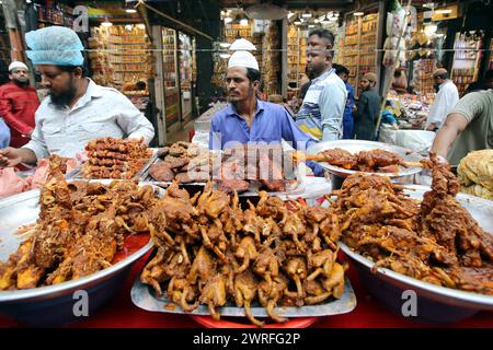 12 mars 2024, Dhaka, Wari, Bangladesh : les musulmans bangladais achètent de la nourriture pour rompre leur jeûne pendant le premier jour du mois de jeûne du Ramadan sur un marché alimentaire traditionnel au bazar de Chalk, à Dhaka, Bangladesh, le 12 mars 2024. Le mois sacré du Ramadan pour les musulmans est le neuvième mois du calendrier islamique, et on croit que la révélation du premier verset du Coran a eu lieu au cours de ses 10 dernières nuits. C’est aussi un moment de socialisation, principalement le soir après avoir rompu le jeûne, et un déplacement de toutes les activités vers la fin de la journée dans la plupart des pays. (Crédit image : © Habibur Rahman/ZUMA Pre Banque D'Images