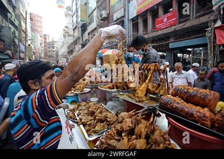 12 mars 2024, Dhaka, Wari, Bangladesh : les musulmans bangladais achètent de la nourriture pour rompre leur jeûne pendant le premier jour du mois de jeûne du Ramadan sur un marché alimentaire traditionnel au bazar de Chalk, à Dhaka, Bangladesh, le 12 mars 2024. Le mois sacré du Ramadan pour les musulmans est le neuvième mois du calendrier islamique, et on croit que la révélation du premier verset du Coran a eu lieu au cours de ses 10 dernières nuits. C’est aussi un moment de socialisation, principalement le soir après avoir rompu le jeûne, et un déplacement de toutes les activités vers la fin de la journée dans la plupart des pays. (Crédit image : © Habibur Rahman/ZUMA Pre Banque D'Images