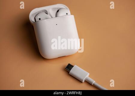 Une image d'airpods sur un fond orange avec le nouveau type c charger.Hincesti,Moldova,11.09.2023 Banque D'Images