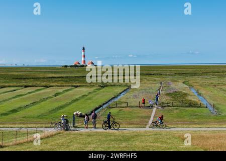 Leuchtturm von Westerhever an der Nordseeküste auf der Halbinsel Eiderstdt in Schleswig-Holstein, Radfahrer und Wanderer im Vordergrund Banque D'Images