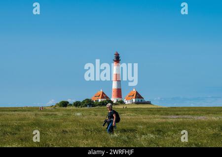 Leuchtturm von Westerhever an der Nordseeküste auf der Halbinsel Eiderstdt in Schleswig-Holstein eine Fotografin im Vordergrund Banque D'Images