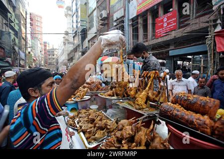 12 mars 2024, Dhaka, Wari, Bangladesh : les musulmans bangladais achètent de la nourriture pour rompre leur jeûne pendant le premier jour du mois de jeûne du Ramadan sur un marché alimentaire traditionnel au bazar de Chalk, à Dhaka, Bangladesh, le 12 mars 2024. Le mois sacré du Ramadan pour les musulmans est le neuvième mois du calendrier islamique, et on croit que la révélation du premier verset du Coran a eu lieu au cours de ses 10 dernières nuits. C’est aussi un moment de socialisation, principalement le soir après avoir rompu le jeûne, et un déplacement de toutes les activités vers la fin de la journée dans la plupart des pays. (Crédit image : © Habibur Rahman/ZUMA Pre Banque D'Images