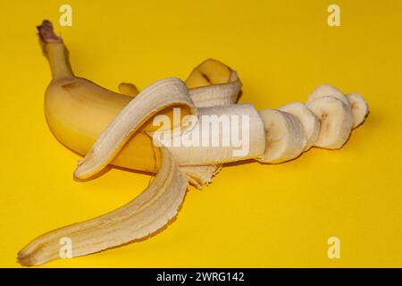 Bananes fraîches de bébé mûres tombant dans l'air isolées sur fond jaune. Concept de lévitation alimentaire. Image haute résolution. Photo de haute qualité Banque D'Images