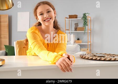 Jeune femme rousse souriante à la maison Banque D'Images