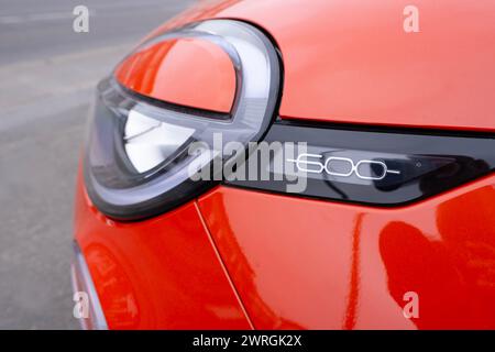 Lampe en gros plan, détail logo rouge électrique Fiat 600 Е voiture dans le parking, crossover compact, constructeur automobile italien Fiat Group, innovation Automotive in Banque D'Images