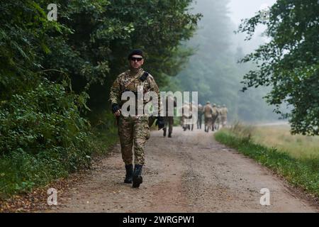 Un groupe de soldats d'élite conduit les captifs dans un camp militaire, mettant en évidence une atmosphère tendue de détention et d'opérations de sécurité Banque D'Images