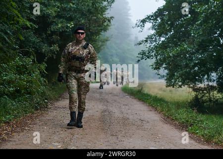 Un groupe de soldats d'élite conduit les captifs dans un camp militaire, mettant en évidence une atmosphère tendue de détention et d'opérations de sécurité Banque D'Images