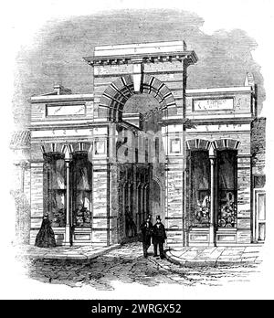 Entrée au Agricultural Hall depuis High-Street, Islington, [Londres], 1862. Site du salon du bétail et des outils du Smithfield Club. « Mille tonnes de fer sont utilisées dans sa construction, et la toiture contient neuf milles de barre de fer, plus d'un acre de verre, et deux acres d'ardoise, tandis que l'espace offert par les galeries est considérablement au-dessus d'un acre. Les tours... sont construites en vue d'aider à la ventilation. Les piliers de fer qui soutiennent les parties centrales du tissu forment des tubes de drainage du toit au sous-sol et les appareils de drainage sous...le buil Banque D'Images