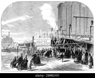 Le chemin de fer de Charing-Cross : entrée temporaire de la gare depuis Villiers-Street, [Londres], 1864. 'L'entrée temporaire de la gare ne servira ci-après que pour les taxis vides, qui passeront ainsi vers le quai d'arrivée, sur le côté ouest, près de l'endroit où les fonctionnaires de la douane seront prêts à examiner les bagages apportés par les trains continentaux. La cabine-rang est maintenant stationnée sous la première arche vue après être entrée dans l'habitacle temporaire. En passant par le rang, et sous un hangar pour se protéger des intempéries, nous...[suivant] entrons dans la chaussée en forme de tunnel utilisée pour le passage Banque D'Images