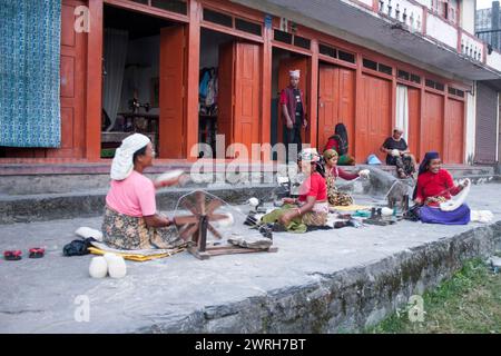 Pokhara, Népal - 3 NOVEMBRE 2006. La femme non identifiée filant de la laine dans la rue Pokhara, Népal. Banque D'Images