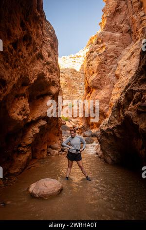 Femme Stants dans Deep Canyon Creek avec ses mains sur ses hanches et fait Un visage drôle dans Capitol Reef Banque D'Images