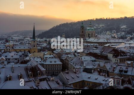 Ceci est une vue de la vieille ville des toits de neige pendant le coucher du soleil près du château de Prague le 13 décembre 2022 à Prague, République tchèque Banque D'Images