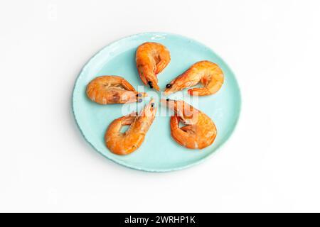 Crevettes, crevettes dans l'assiette, vue de dessus, espace de copie. Ingrédient de fruits de mer frais - prêt pour la cuisson. Crevettes bouillies isolées sur fond blanc Banque D'Images