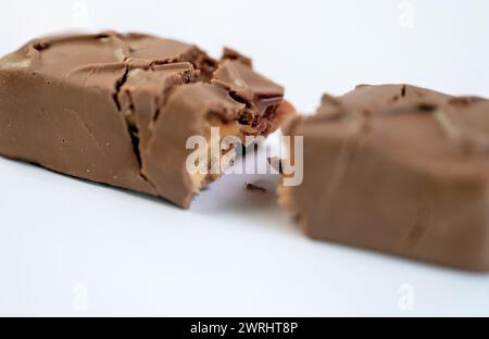 Une vue rapprochée de diverses barres de chocolat artistiquement disposées sur un fond blanc immaculé Banque D'Images