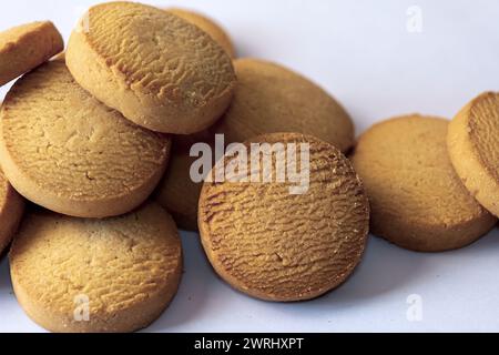 Un plan macro appétissant de biscuits au beurre, mettant en valeur leur texture délicieuse et leur riche couleur sur un fond blanc propre Banque D'Images