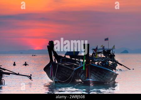 Bateau longtail au coucher du soleil à la plage de Railay, ambiance du soir, soleil, soirée, bateau, mer, paysage marin, nuage, soleil rouge, romantique, océan, nature, vacances à la plage Banque D'Images