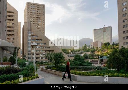 Une femme traverse un lotissement moderne avec des immeubles de grande hauteur à Téhéran, 22/05/2016 Banque D'Images