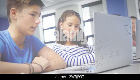 Image d'équations mathématiques sur des écoliers utilisant un ordinateur portable en classe Banque D'Images